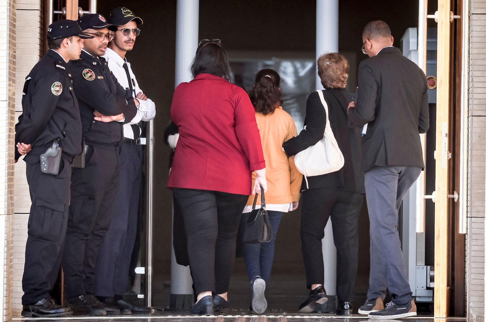 A young Moroccan girl (orange jacket) who was repeatedly raped when she was 11-years old, enters the tribunal before the trial of three men accused of the sexual aggression, Rabat, Morocco, April 13, 2023. (AFP Photo)