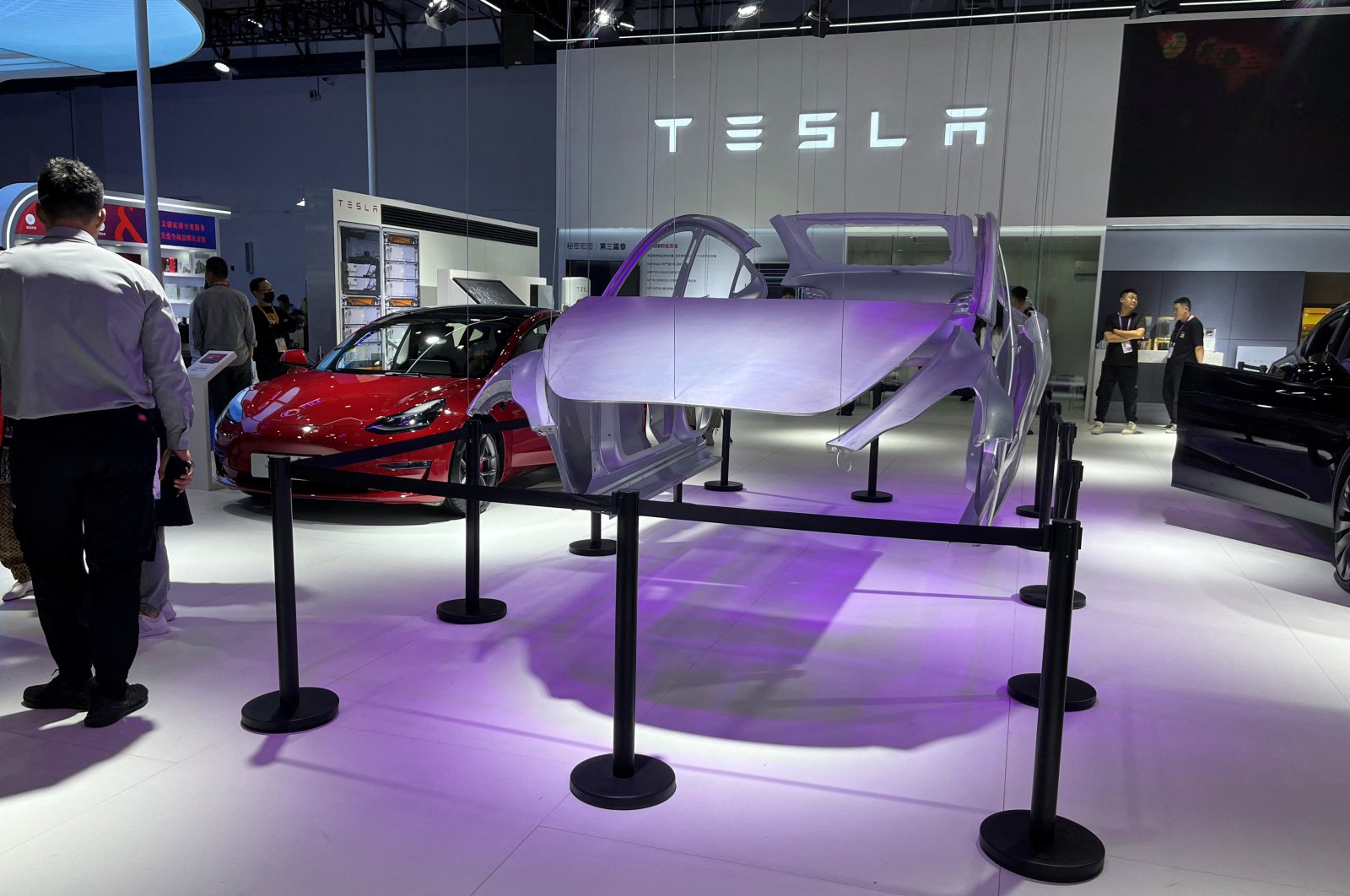 A man stands next to a Tesla Model 3 electric vehicle (EV) display at the third China International Consumer Products Expo, in Haikou, Hainan province, China, April 12, 2023. (Reuters Photo)