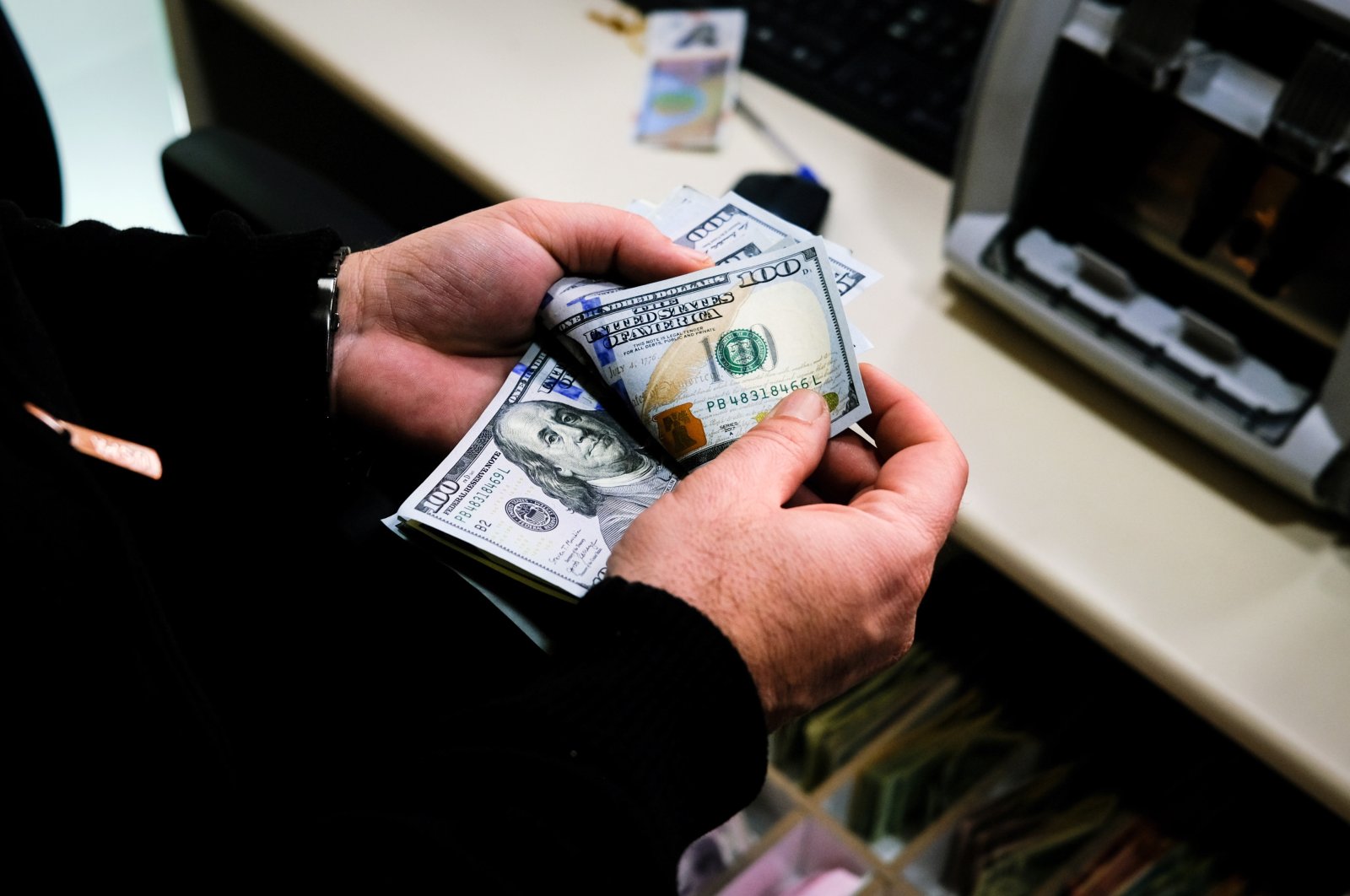 A worker counts U.S. dollars at an exchange office in Istanbul, Türkiye, April 14, 2023. (EPA Photo)