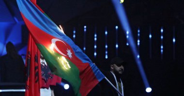 A man sets fire to the flag of Azerbaijan during the opening ceremony of the European Weightlifting Championships, Yerevan, Armenia, April 14, 2023. (Reuters Photo)