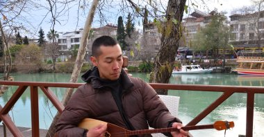 Aman Odun plays a traditional dombra, a long-necked musical string instrument, Antalya, Türkiye, April 15, 2023. (AA Photo)