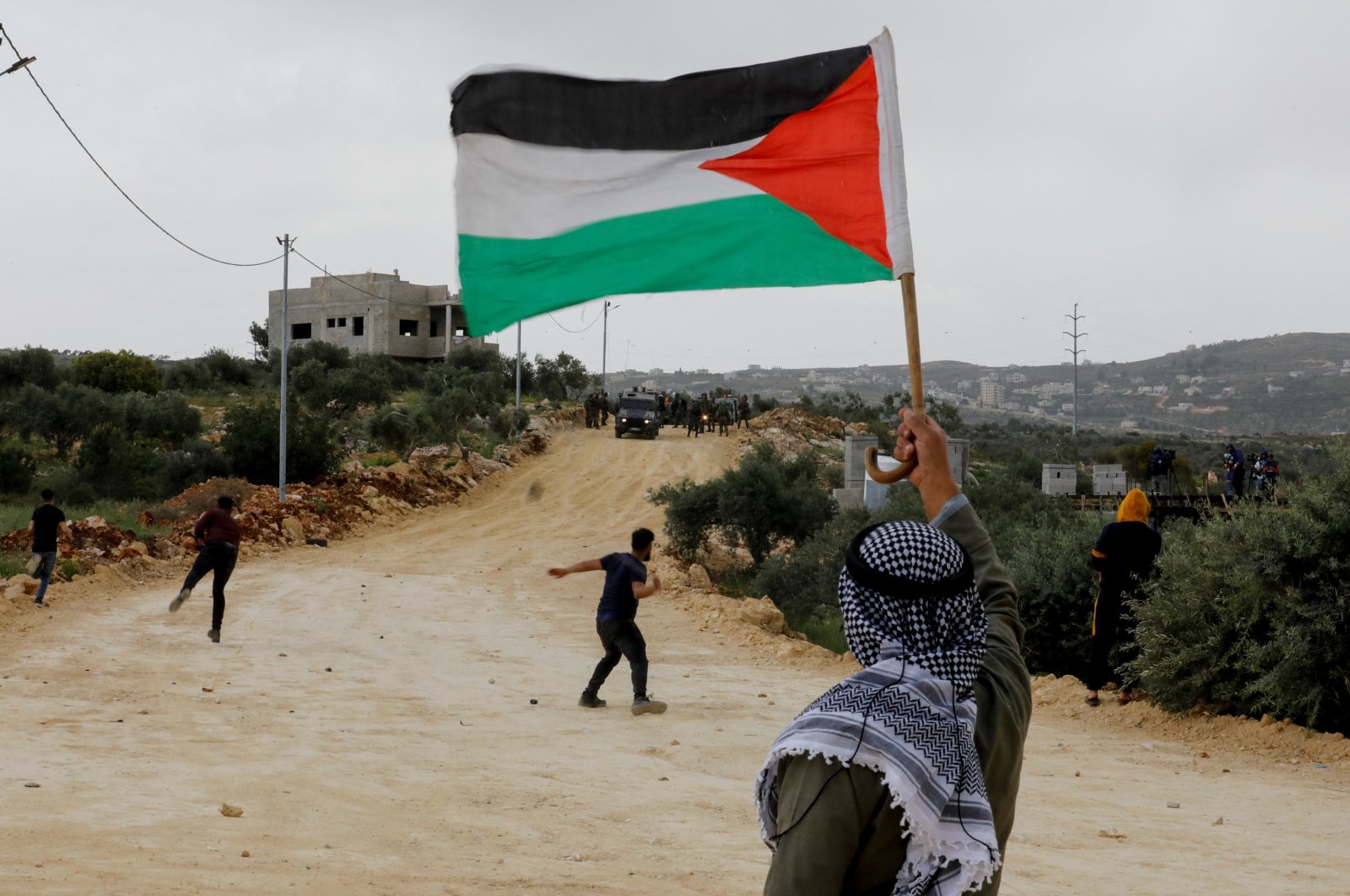 A demonstrator holds a Palestinian flag during clashes with Israeli forces at a protest against Israeli settlements, Nablus, in the Israeli-occupied West Bank, Palestine, April 10, 2023. (Reuters Photo)
