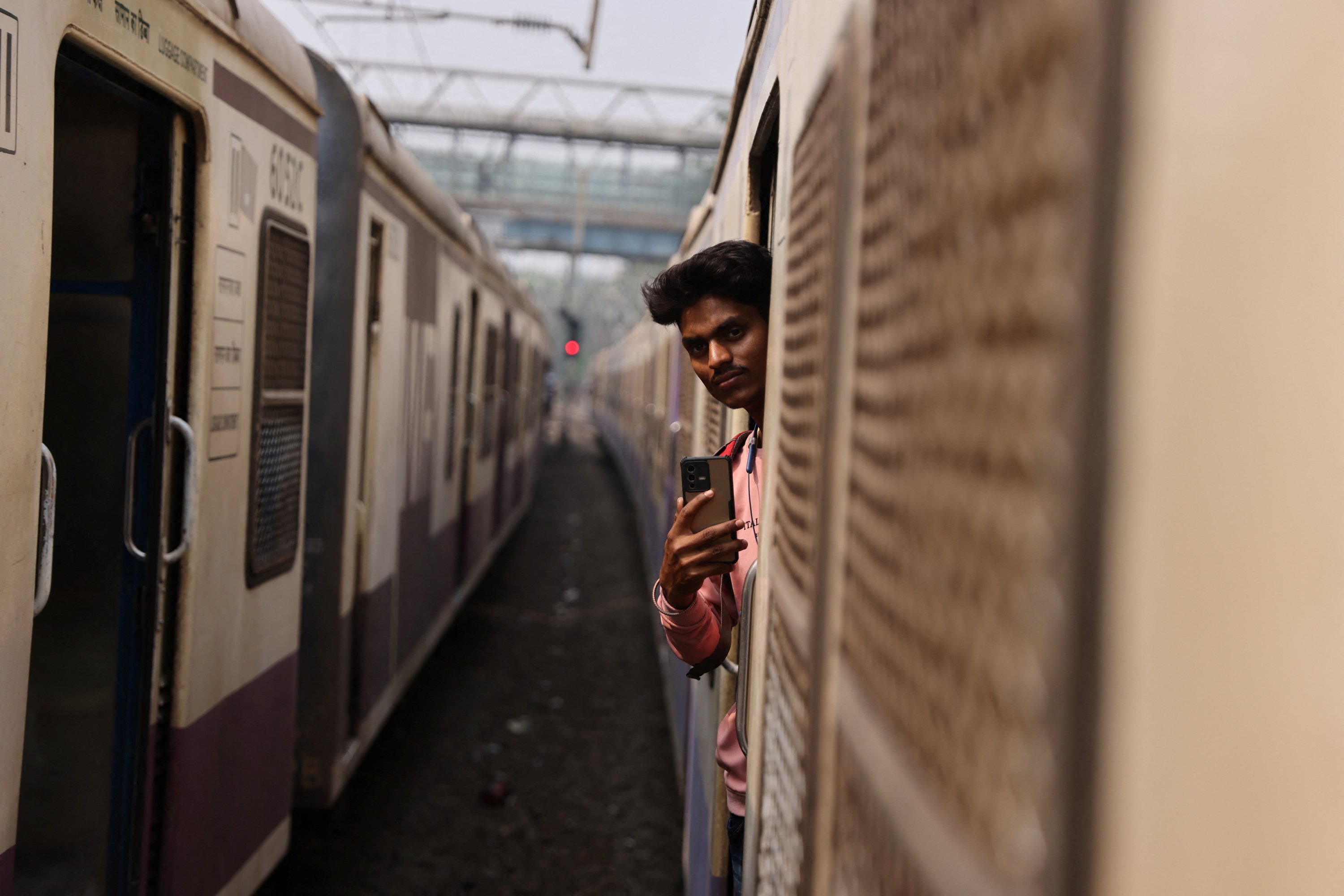 A 21-year-old aspiring college student and migrant worker Sujeet Kumar shoots a video on his mobile phone while on a local train in Mumbai, India, March 13, 2023. (Reuters Photo)