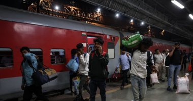 A 21-year-old aspiring college student and migrant worker Sujeet Kumar speaks on his mobile phone after getting off the train at Thane railway station on the outskirts of Mumbai, India, March 11, 2023. (Reuters Photo)