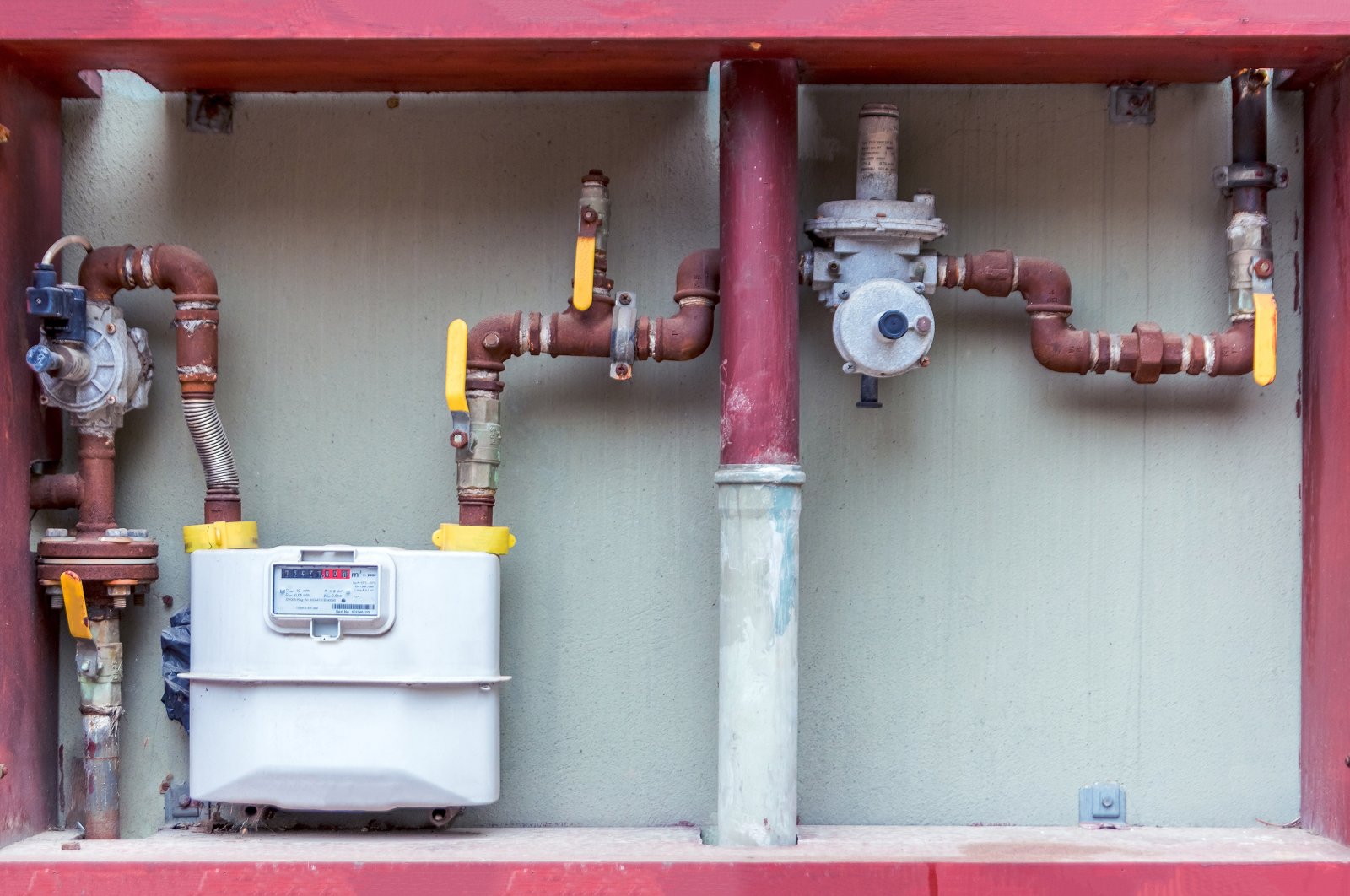 Natural gas meters and red plumbing on an exterior wall to measure household energy consumption is seen in this undated file photo taken in Türkiye. (Shutterstock File Photo)