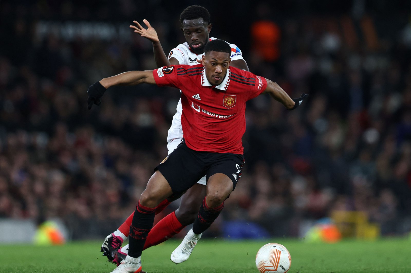 Sevilla&#039;s French defender Tanguy Nianzou (L) vies with Manchester United&#039;s French striker Anthony Martial during the UEFA Europa league quarterfinal, first leg football match at Old Trafford, Manchester, U.K., April 13, 2023. (AFP Photo)