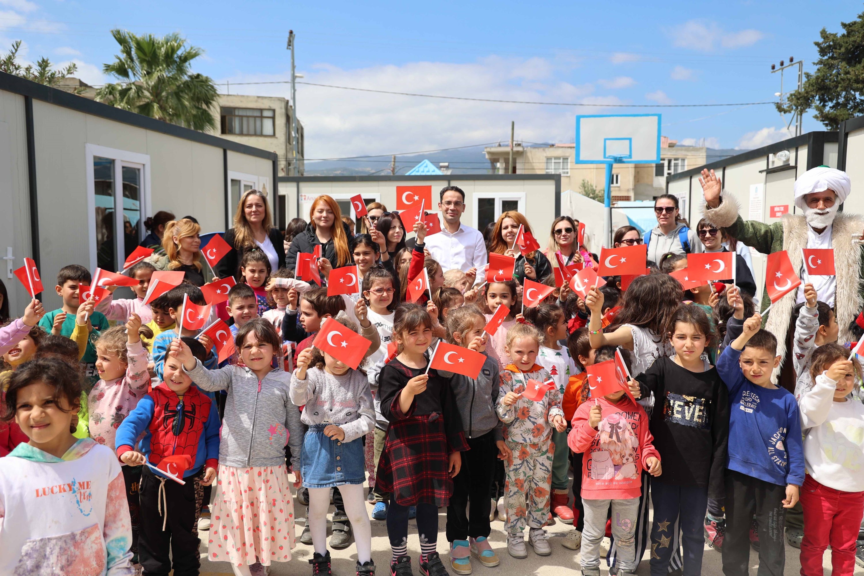 Anak-anak di provinsi yang dilanda gempa Hatay mengibarkan bendera Turki selama kegiatan yang diadakan untuk memperingati Hari Anak, Hatay, Türkiye selatan, 19 April 2023. (Foto IHA)