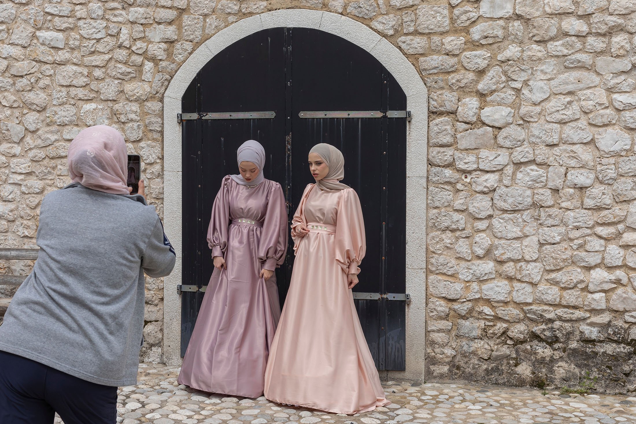 Two females photograph their outfits to wear for Eid al-Fitr, in Ston, Bosnia-Herzegovina, April 23, 2022. (Shutterstock Photo)