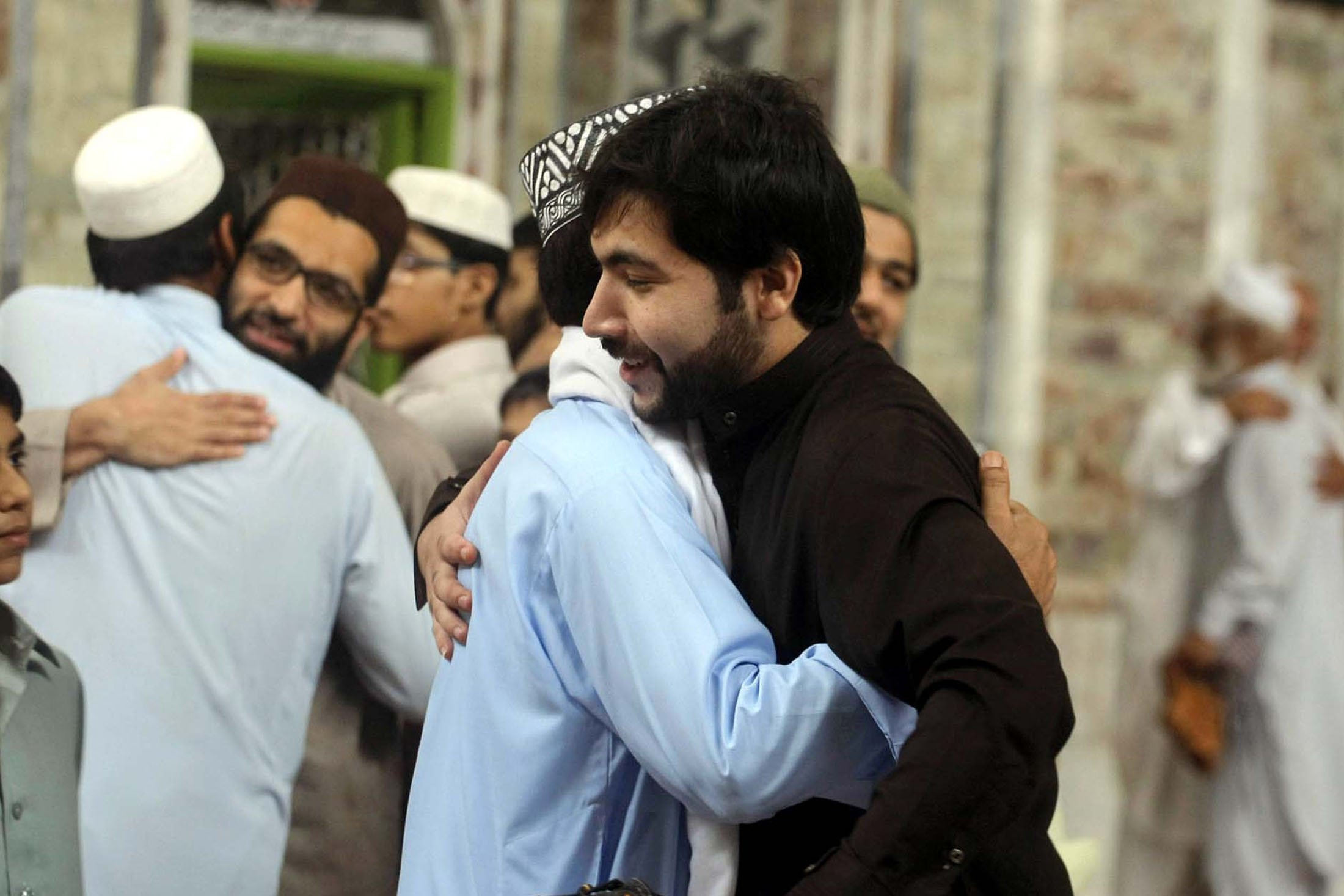 Umat ​​Islam saling berpelukan usai salat Idul Fitri, di Peshawar, Pakistan, 28 Juli 2014. (Foto Shutterstock)