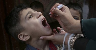 A health worker gives a polio vaccine to a child in Peshawar, Pakistan, June 27, 2022. (AP Photo)