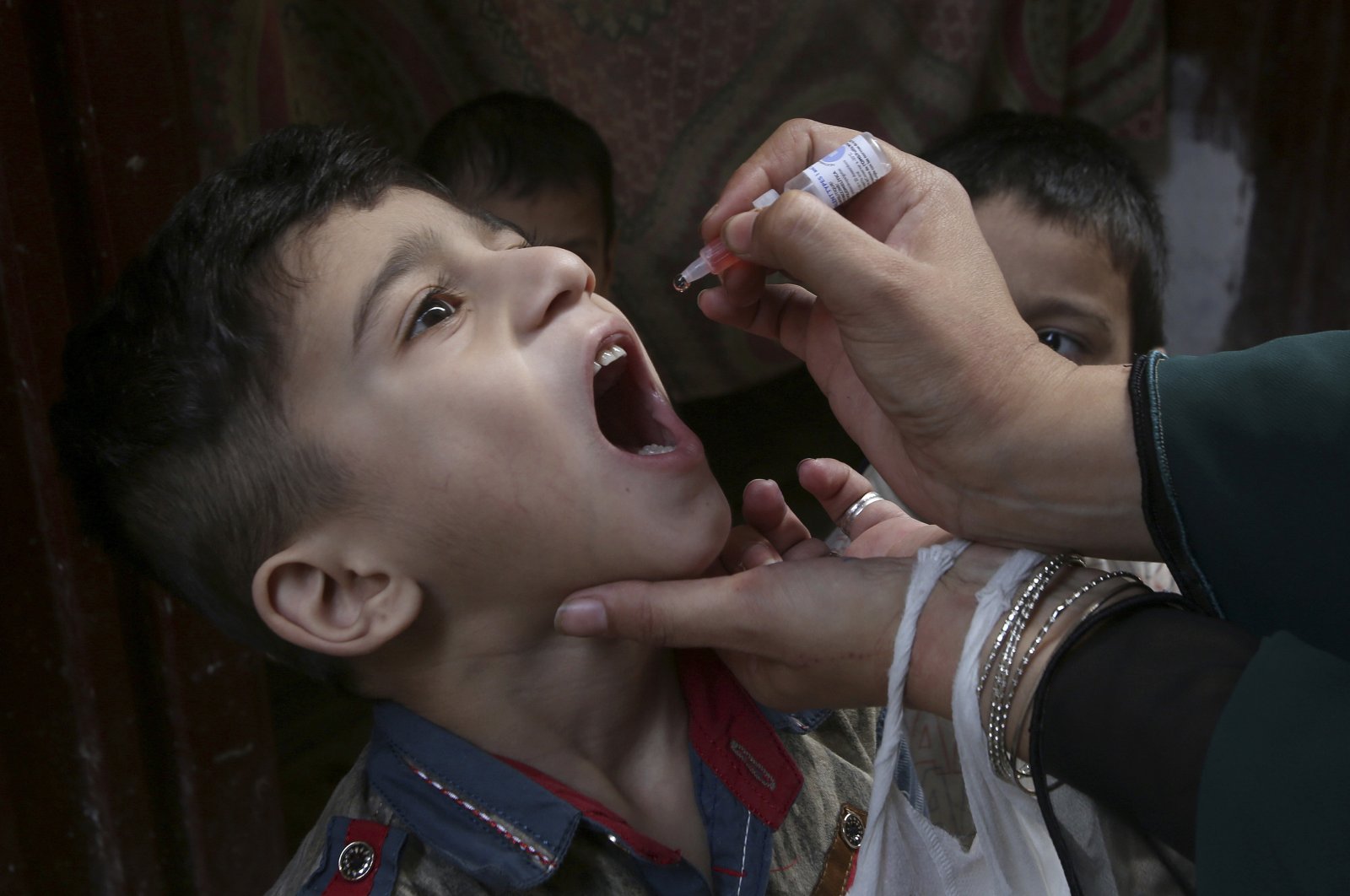 A health worker gives a polio vaccine to a child in Peshawar, Pakistan, June 27, 2022. (AP Photo)