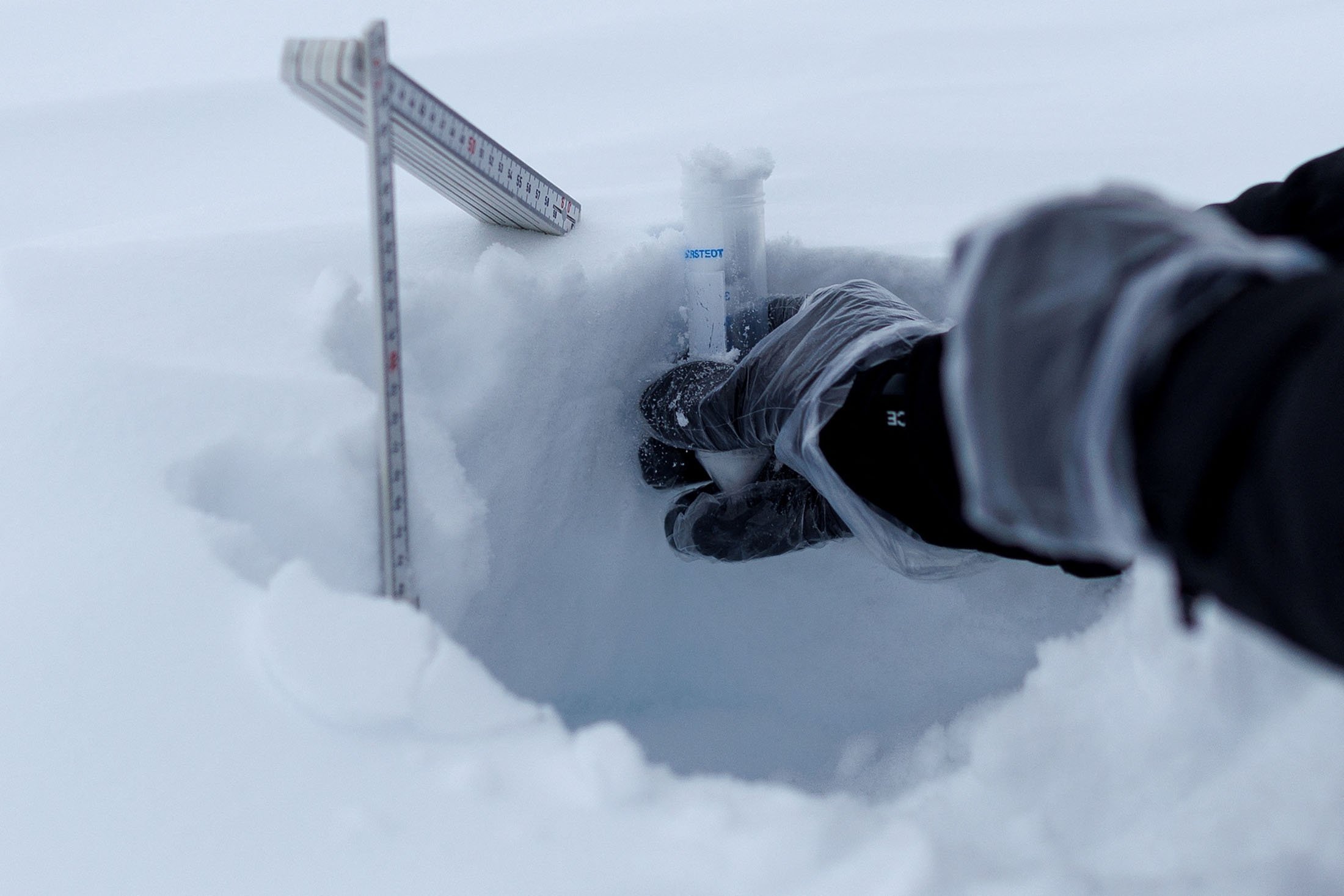 Ahli kimia Institut Paul Scherrer Swiss, Francois Burgay, mengambil sampel salju untuk mendeteksi molekul yang terhubung dengan ganggang mekar di Ny-Aalesund, Svalbard, Norwegia, 5 April 2023. (Foto Reuters)