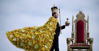 Model Rupert North poses with a floral Coronation cloak, designed by florist Helen James, along with replicas of the St. Edward&#039;s Crown, the Sovereign&#039;s Sceptre with Cross and Sovereign&#039;s Orb during a photocall for a Coronation-themed floral display, on the eve of the Harrogate Spring Flower Show, at The Great Yorkshire Showground in Harrogate, northern U.K., April 19, 2023. (AFP Photo)