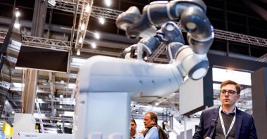 Philip Singer, a business architect for data and AI at Hewlett-Packard Enterprises (HPE), operates a robot, developed in cooperation between HPE and German AI startup Aleph Alpha, that is able to speak and answer questions at the HANNOVER MESSE 2023, the Hanover technology fair, in Hanover, Germany, April 17, 2023. (AFP Photo)