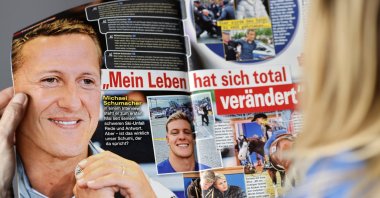A woman reads the edition of German weekly magazine Die Aktuelle with the cover announcing a fake interview with Michael Schumacher, Berlin, Germany, April 20, 2023. (EPA Photo)