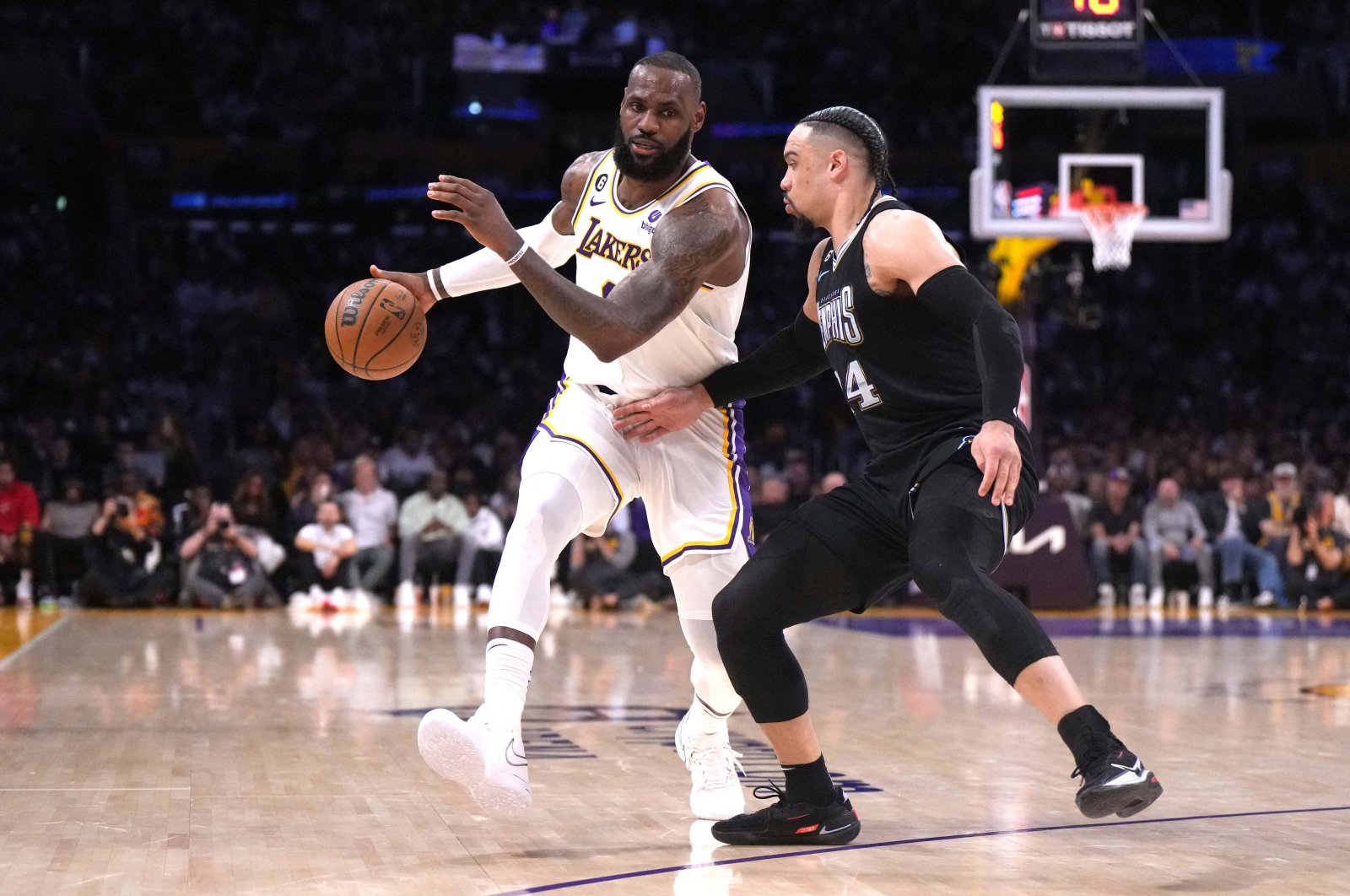 Los Angeles Lakers forward LeBron James (L) dribbles the ball against Memphis Grizzlies forward Dillon Brooks (R) in the second quarter during game three of the 2023 NBA playoffs at Crypto.com Arena, Los Angeles, U.S., April 22, 2023. (Reuters Photo)