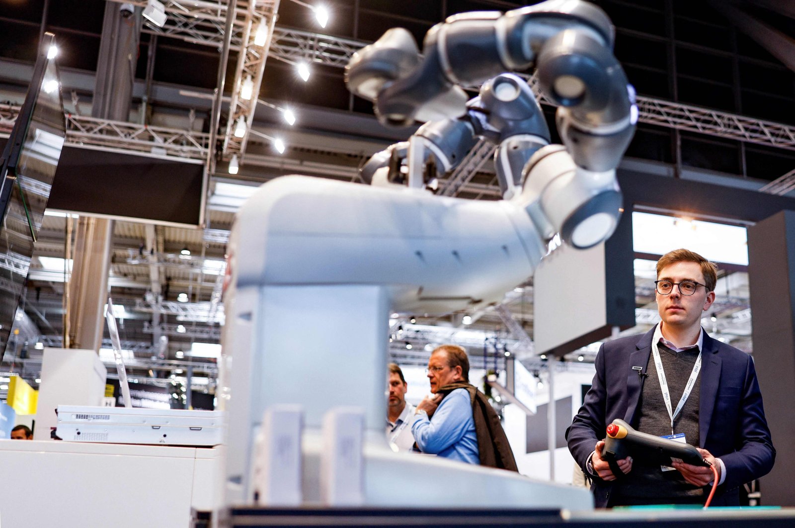 Philip Singer, a business architect for data and AI at Hewlett-Packard Enterprises (HPE), operates a robot, developed in cooperation between HPE and German AI startup Aleph Alpha, that is able to speak and answer questions at the HANNOVER MESSE 2023, the Hanover technology fair, in Hanover, Germany, April 17, 2023. (AFP Photo)