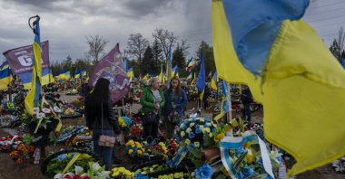 Friends and relatives visit the grave of a Ukrainian serviceperson at the Kryvyi Rih cemetery in eastern Ukraine, April 23, 2023. (AP Photo)