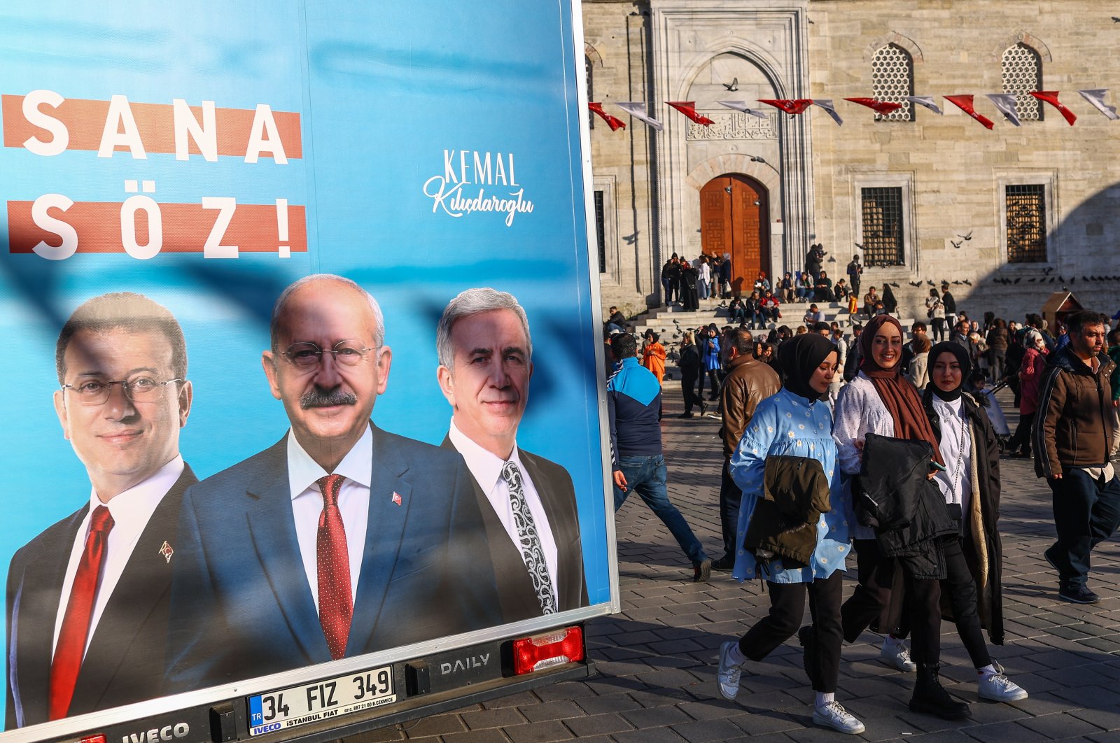 People walk past a campaign van showing pictures of opposition bloc presidential candidate Kemal Kılıçdaroğlu (C), Istanbul Mayor Ekrem Imamoğlu (L) and Ankara Mayor MansurYavaş (R), in Istanbul, Türkiye, April 23, 2023. (EPA Photo)