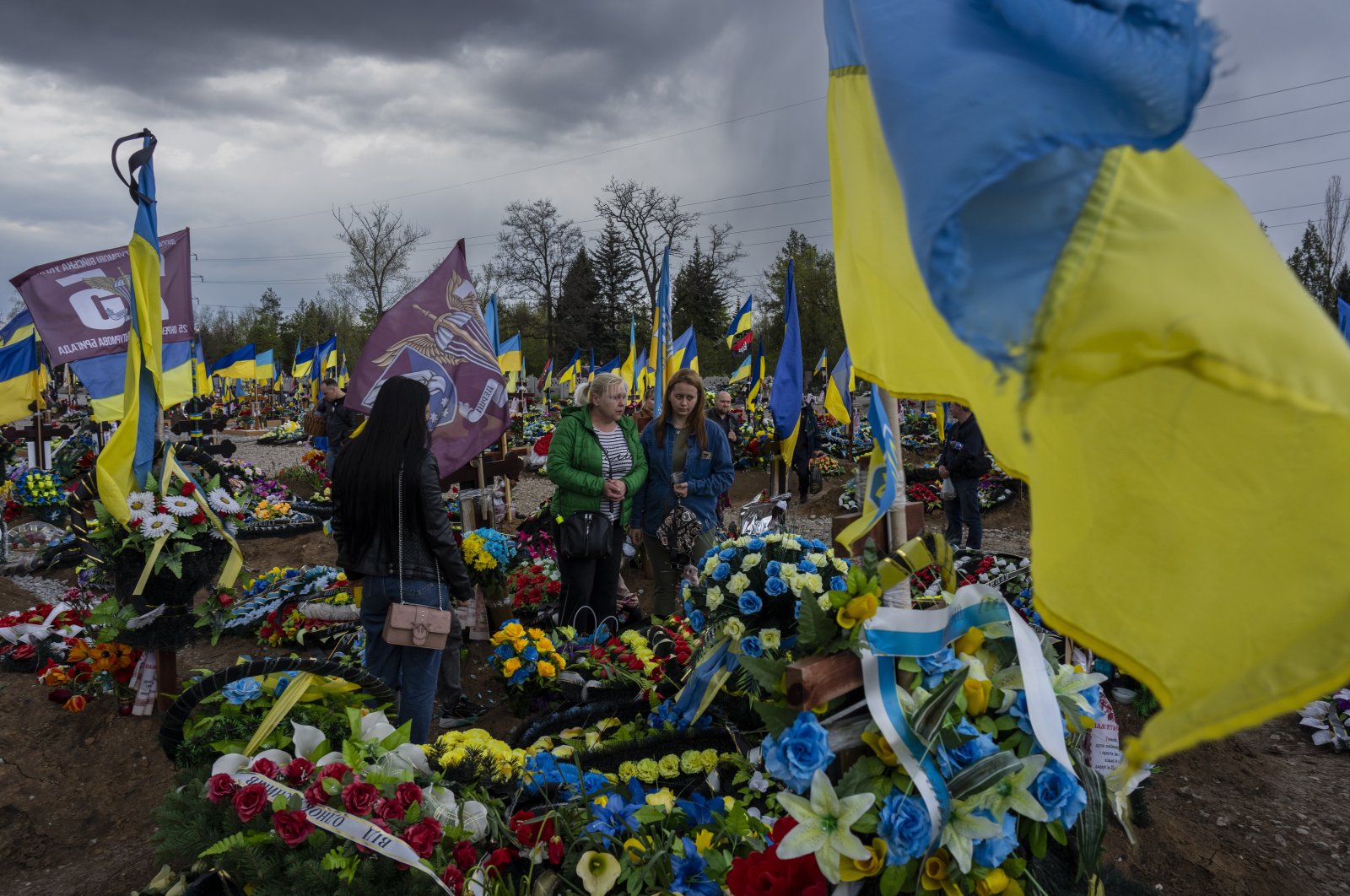 Friends and relatives visit the grave of a Ukrainian serviceperson at the Kryvyi Rih cemetery in eastern Ukraine, April 23, 2023. (AP Photo)