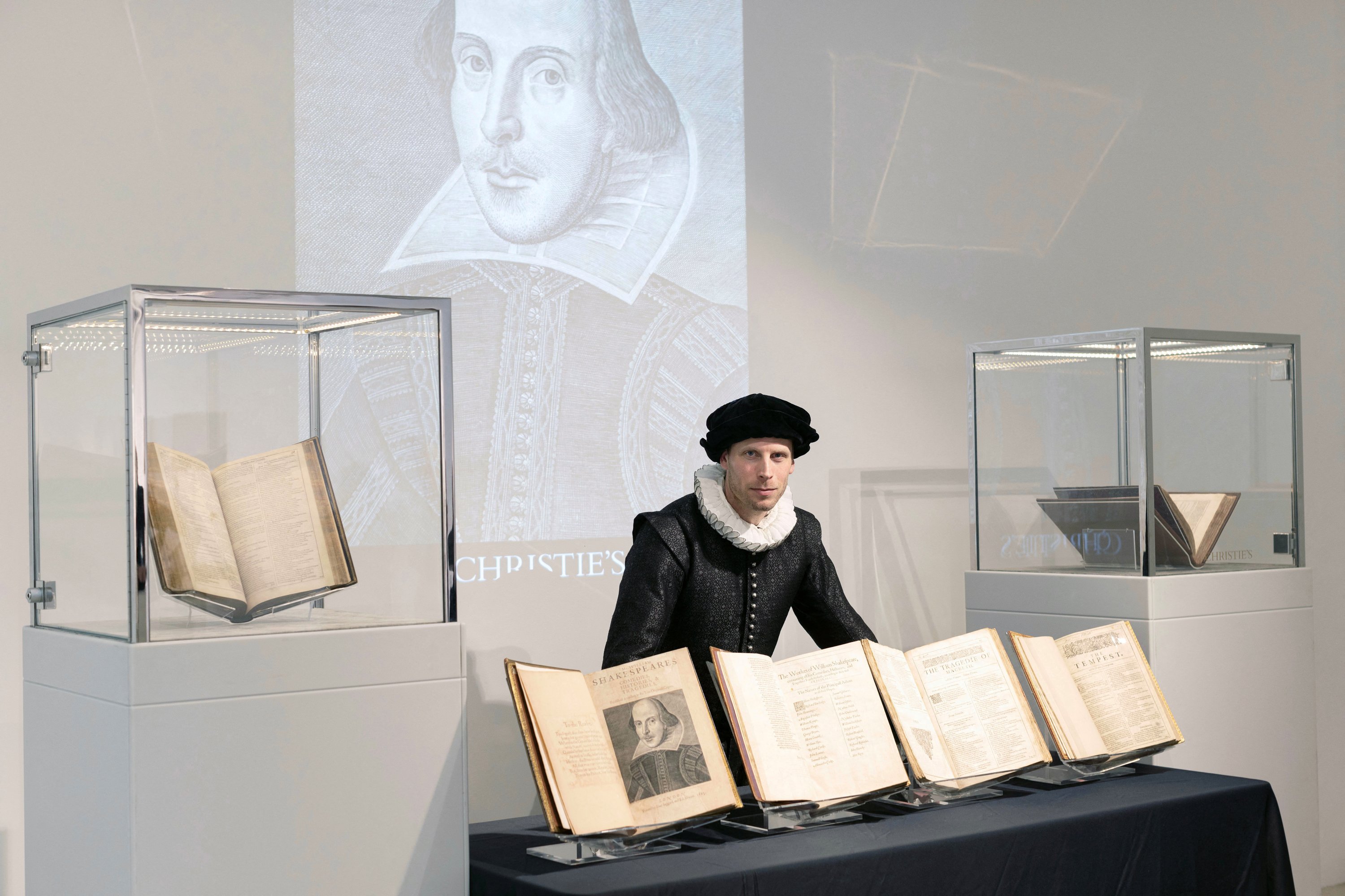 Aktor Sam Oatley dari teater Globe berpose dengan Folio Pertama Willam Shakespeare, dipajang di Christie's di London, Inggris, 24 April 2023. (Foto Reuters)