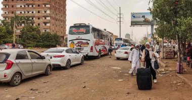People prepare to board a bus departing from Khartoum in the Sudanese capital's south on April 24, 2023, as battles rage in the city between the army and paramilitaries. (Photo by AFP)