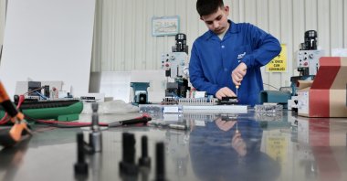 A high school student works on a machine that turns leftovers into pet food, Konya, central Türkiye, April 26, 2023. (AA Photo)