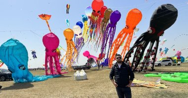 Zahit Mungan posing with his figure themed kites in the background in Mardin, southeastern Türkiye, April 25, 2023. (Photo by Serkan Ünlü)