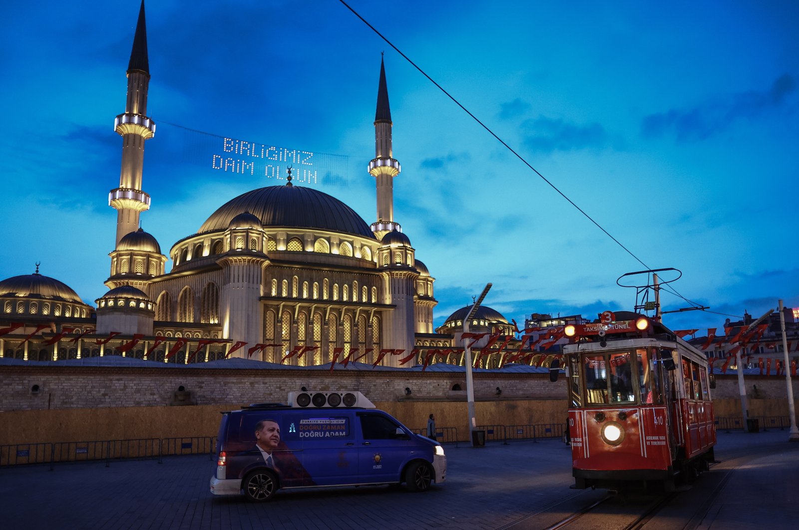 A tram passes by an election campaign car of President Recep Tayyip Erdoğan in front of Taksim Mosque in Istanbul, Türkiye, April 19, 2023. (EPA Photo)