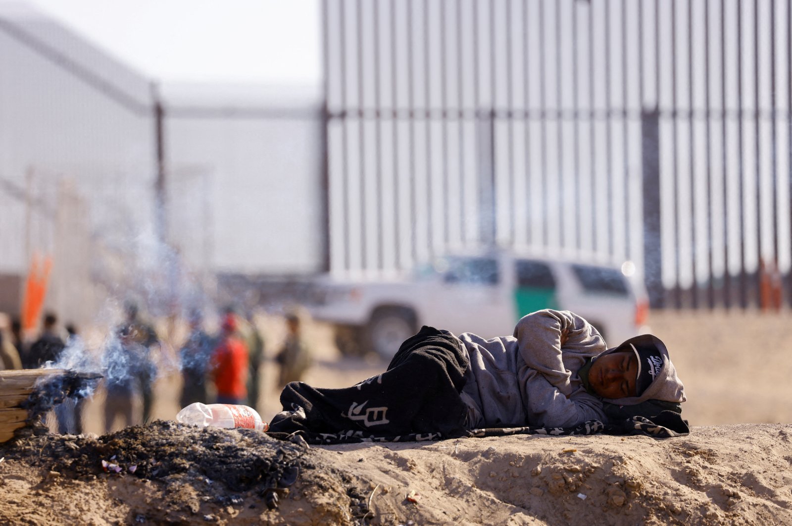 A migrant sleeps, after crossing the Rio Bravo river border between Mexico and the United States, while waiting to turn himself in to U.S. Border Patrol agents, seen from Ciudad Juarez, Mexico, April 25, 2023. (Reuters Photo)