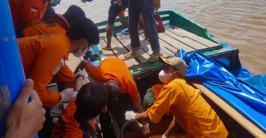 This handout picture taken and released by the Indonesia Search and Rescue Agency (BASARNAS) shows rescue workers moving victim's bodies after a passenger boat overturned shortly after leaving Tembilahan port in Indragiri Hilir Regency, Pekanbaru, Indonesia, April 28, 2023. (AFP Photo)