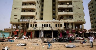 A man walks near a damaged car and buildings at the central market during clashes between the paramilitary Rapid Support Forces and the army, Khartoum, Sudan, April 27, 2023. (Reuters Photo)
