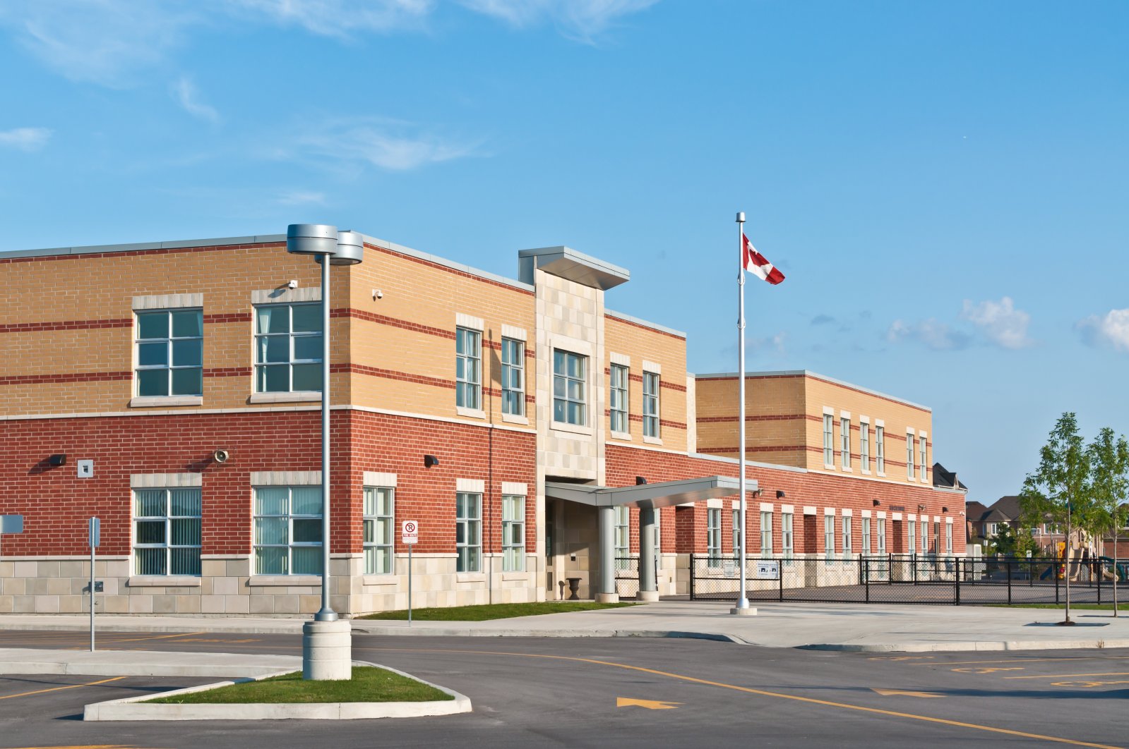A new Canadian elementary school building with a flagpole and parking lot in this undated file photo. (Shutterstock File Photo)