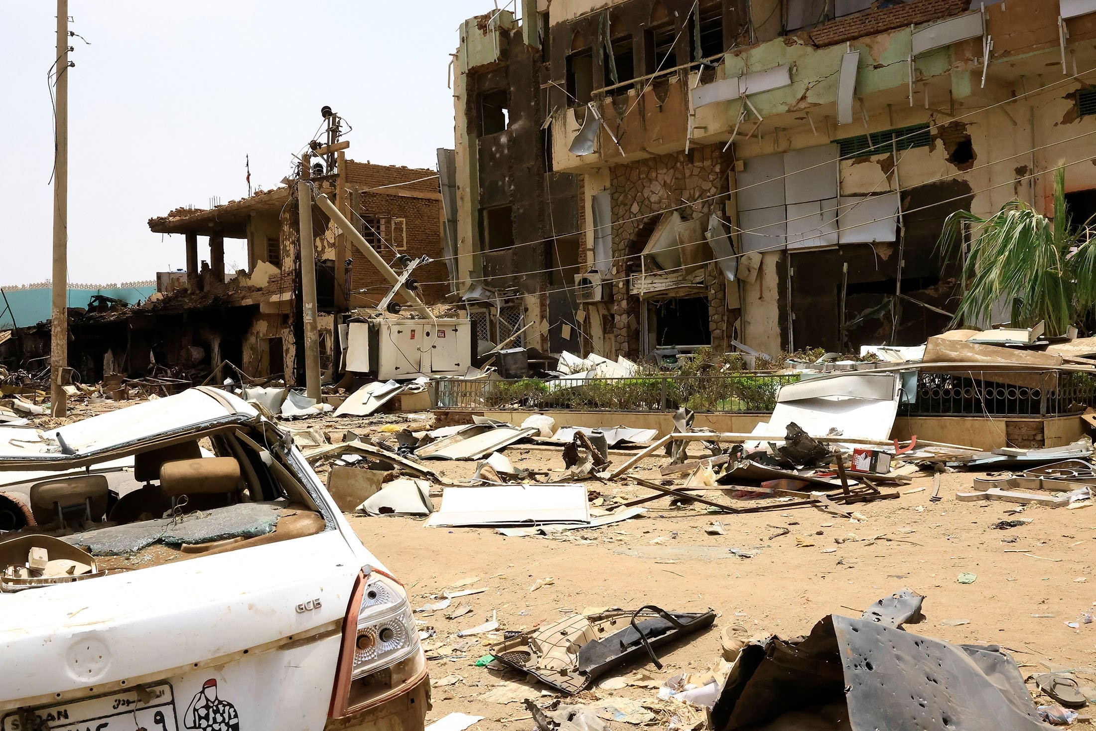 Damaged car and buildings are seen at the central market during clashes between the paramilitary Rapid Support Forces and the army in Khartoum, Sudan, April 27, 2023. (Reuters Photo)