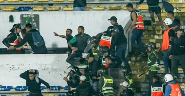 Police breaks up infighting amongst Raja fans during the CAF Champions League quarterfinal football match between Morocco&#039;s Raja Casablanca and Egypt&#039;s Al Ahly at Mohammed V Stadium, Casablanca, Morocco, April 29, 2023. (AFP Photo)
