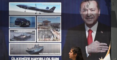 A woman walks past a billboard with the portrait of President Recep Tayyip Erdoğan in Şanlıurfa, southeastern Türkiye, April 28, 2023. (AFP Photo)