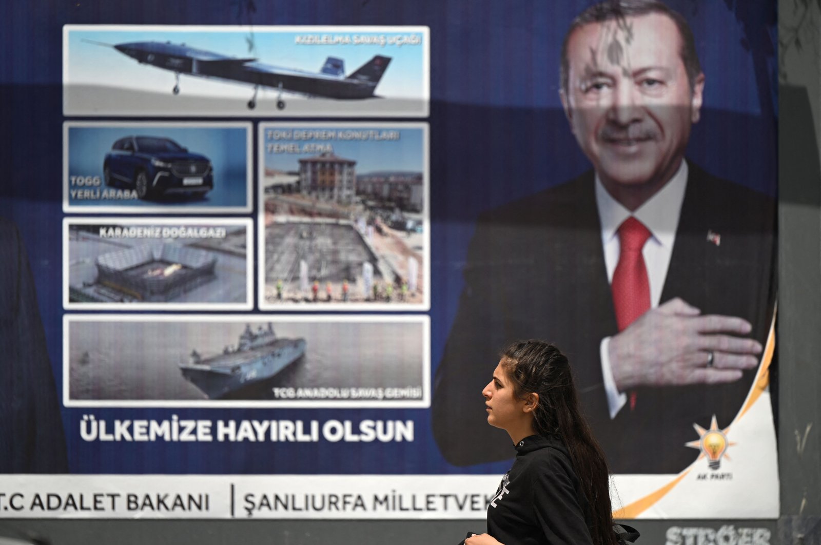 A woman walks past a billboard with the portrait of President Recep Tayyip Erdoğan in Şanlıurfa, southeastern Türkiye, April 28, 2023. (AFP Photo)
