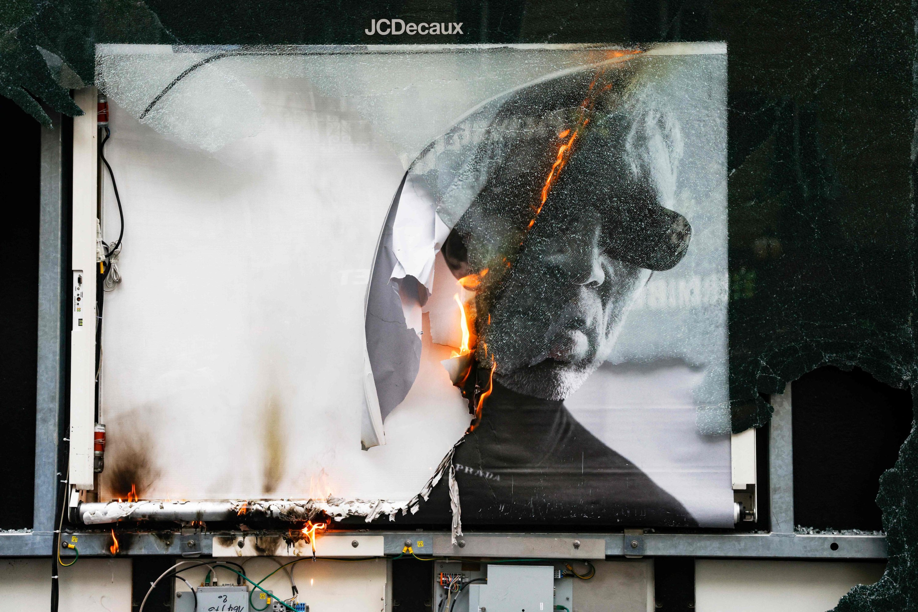 Api membakar iklan di papan reklame saat demonstrasi May Day di Paris, Prancis, 1 Mei 2023. (Foto AFP)