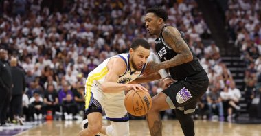Golden State Warriors' Stephen Curry (L) dribbles against Sacramento Kings' Malik Monk during the fourth quarter in game seven of the Western Conference First Round Playoffs at Golden 1 Center, Sacramento, U.S., April 30, 2023. (AFP Photo)