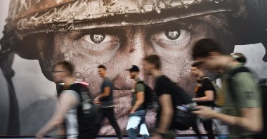 Visitors pass an advertisement for the video game "Call of Duty" at the Gamescom fair for computer games in Cologne, Germany, Aug. 22, 2017. (AP Photo)