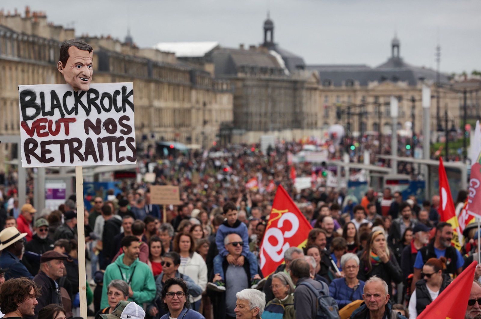 A placard that reads &quot;Blackrock wants our pensions&quot; is pictured as protesters march along Quai de Richelieu along the Garonne river during a demonstration on May Day (Labor Day) to mark the international day of the workers, more than a month after the government pushed an unpopular pensions reform act through parliament, in Bordeaux, southwestern France, May 1, 2023. (AFP Photo)