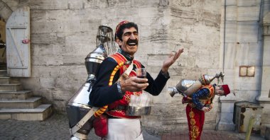 A photograph by Steve McCurry shows a vendor, also known as a şerbetçi, selling a juice called sharbat on the streets of Istanbul, Türkiye, Nov. 9, 2017. (Photo courtesy of Istanbul Cinema Museum)
