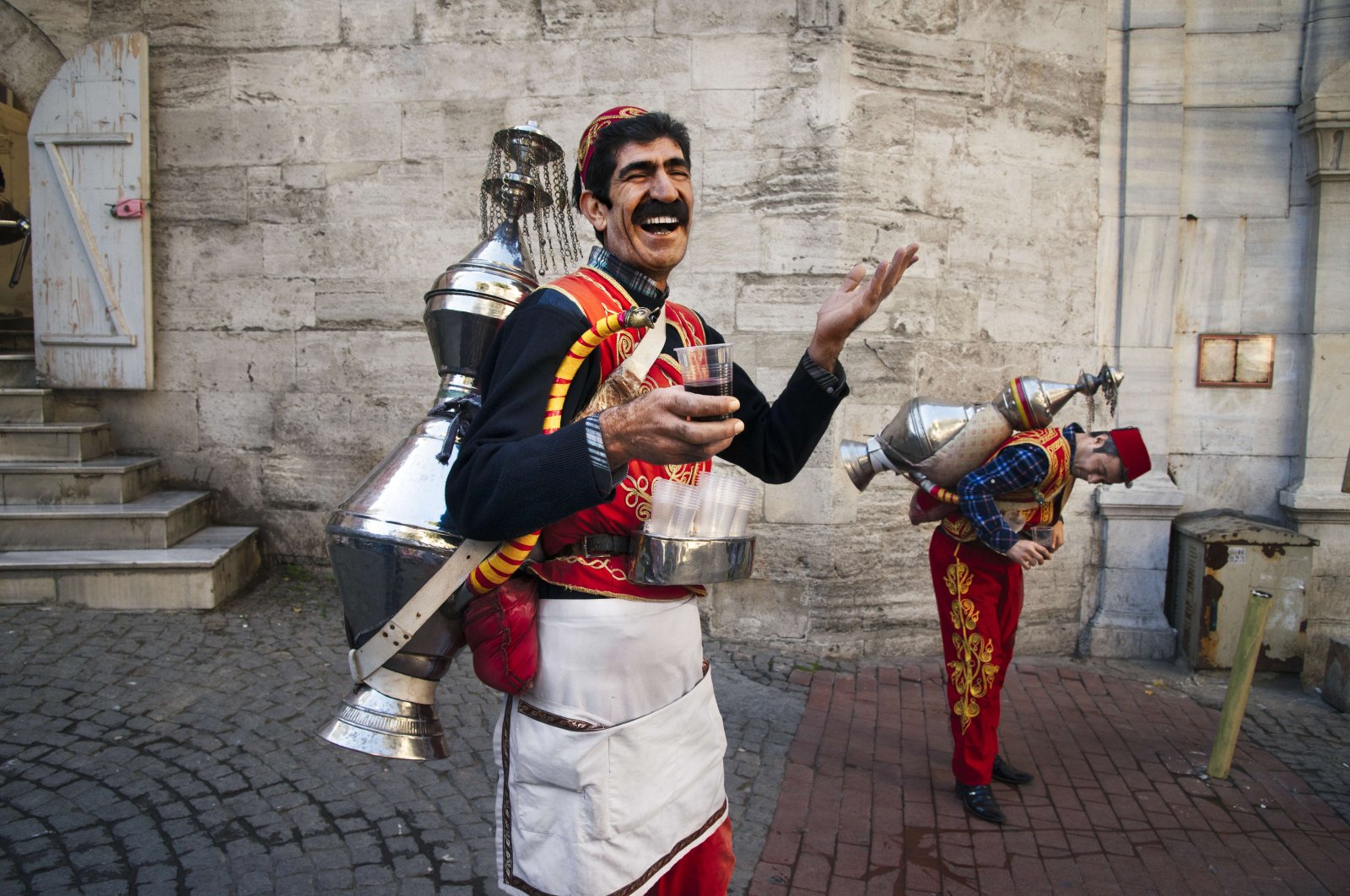 A photograph by Steve McCurry shows a vendor, also known as a şerbetçi, selling a juice called sharbat on the streets of Istanbul, Türkiye, Nov. 9, 2017. (Photo courtesy of Istanbul Cinema Museum)