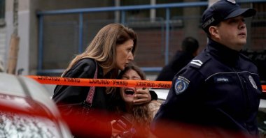 A parent escorts her child following a shooting at a school in the capital Belgrade on May 3, 2023. (AFP Photo)
