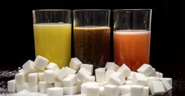 (Left to right) Orange, cola and fruit mix carbonated drinks surrounded by sugar cubes in this undated file photo. (Reuters File Photo)