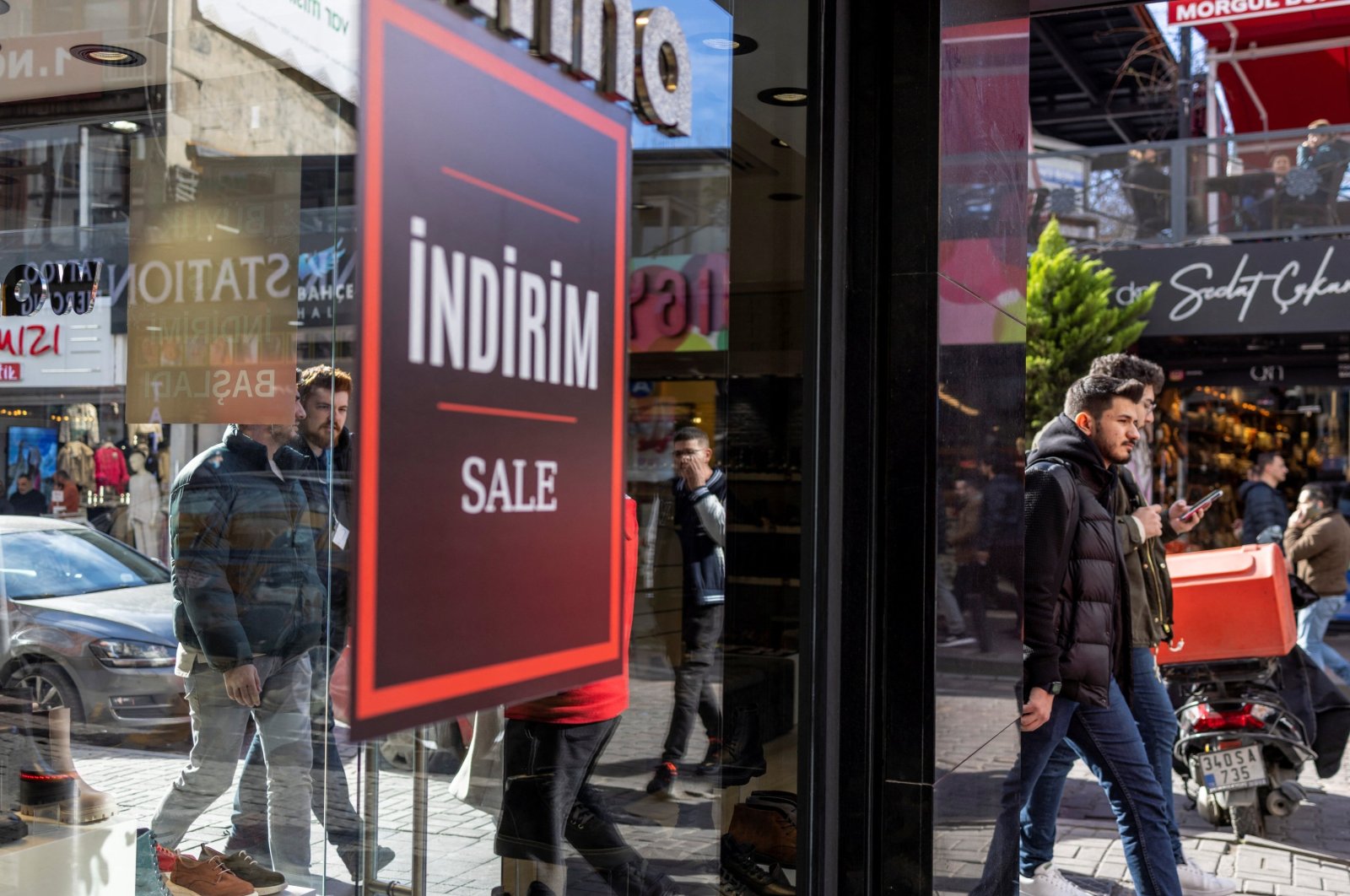 People walk past a shop advertising sales in Istanbul, Türkiye, Jan. 19, 2023. (Reuters Photo)