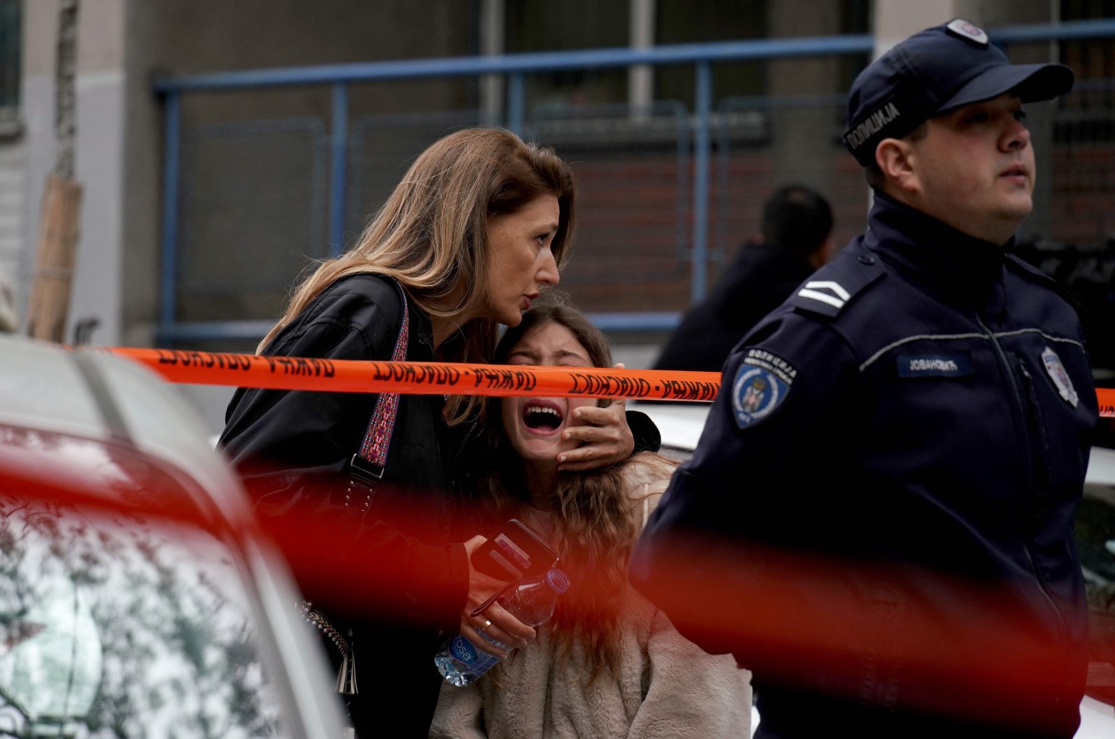 A parent escorts her child following a shooting at a school in the capital Belgrade on May 3, 2023. (AFP Photo)
