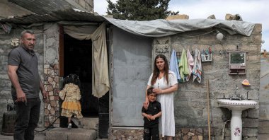 Hayam (R), a 26-year-old displaced Iraqi woman from the Yazidi community, poses for a picture outside a home during an interview with her husband Marwan and children in the region of Sharya, some 15 kilometers near the northern Iraqi city of Dohuk, April 19, 2023. (AFP Photo)