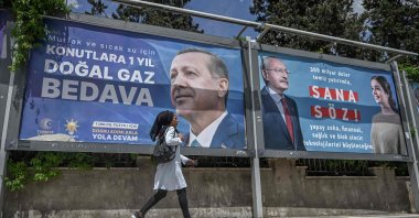 A Syrian woman walks past billboards of incumbent President Recep Tayyip Erdoğan (L) and Kemal Kılıçdaroğlu, in Şanlıurfa, April 28, 2023. (AFP Photo)