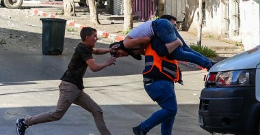 A medic carries an injured man to safety during clashes between Israeli forces and Palestinians following an Israeli army raid in the occupied West Bank city of Nablus, Palestine, May 4, 2023. (AFP Photo)